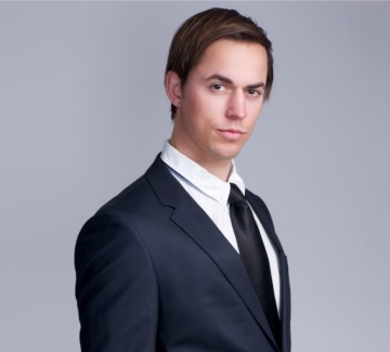 demo-attachment-447-handsome-young-businessman-standing-against-gray-PFGZN4E